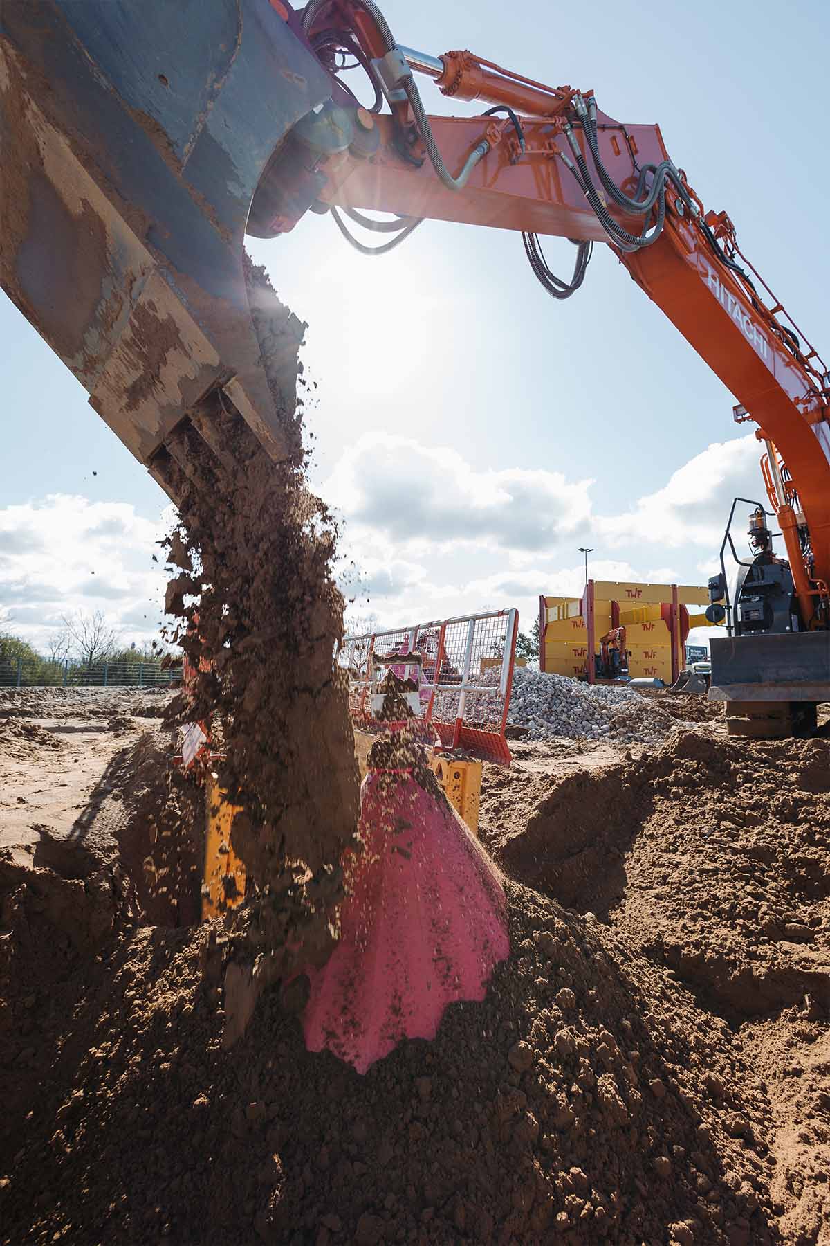 Während der Verfüllung auf einer Baustelle verdeckt die TIBATEK®-Schachtmütze einen Schacht